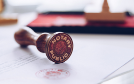 A notary public stamp sitting on a freshly stamped document.
